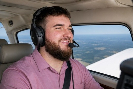 Randall Freeman, flight instructor, smiling at the controls in flight